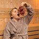 A young child eating grapes in a sauna.